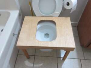 Front view of wooden full squat toilet platform on toilet showing stable base.