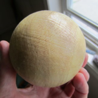 Wooden butt massage ball with rubber coating.