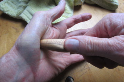 Hand carved massage stick for massaging the thumb muscles.