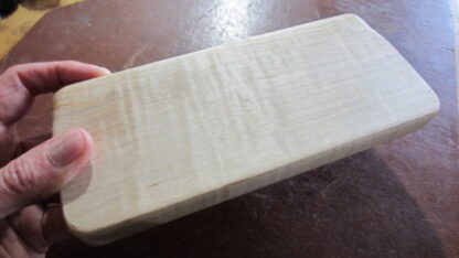 Handheld massage tool has four different edges. Made of solid wood.